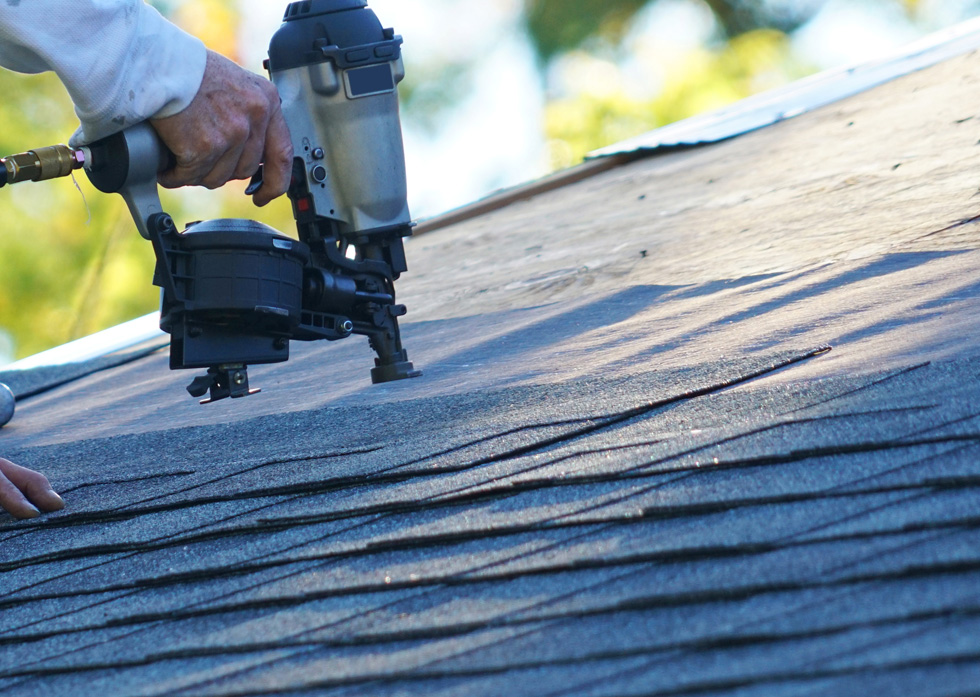 Professional roofing contractor replacing an old residential roof in Branson, MO